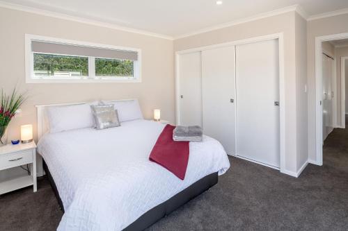 a bedroom with a white bed and a window at Easy Days Martinborough in Martinborough 