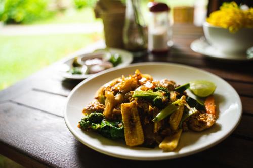 a plate of food on a wooden table at Our Jungle House in Khao Sok