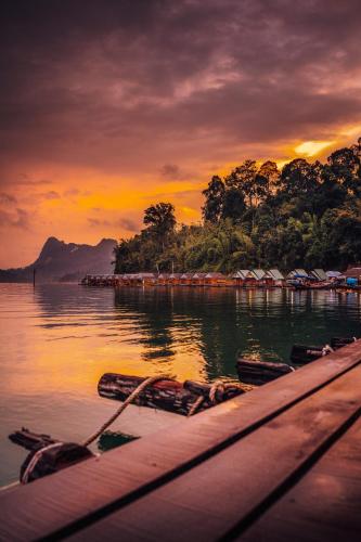 a group of boats on the water at sunset at Our Jungle House in Khao Sok