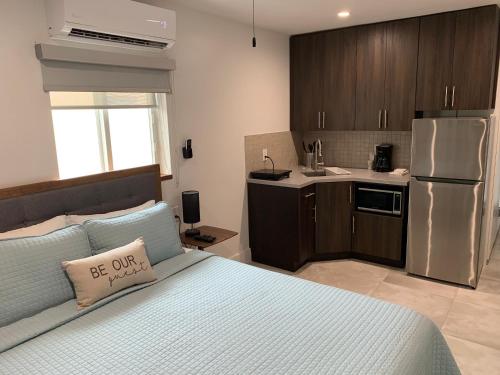 a bedroom with a bed and a kitchen with a refrigerator at Ocean Villas of Deerfield in Deerfield Beach
