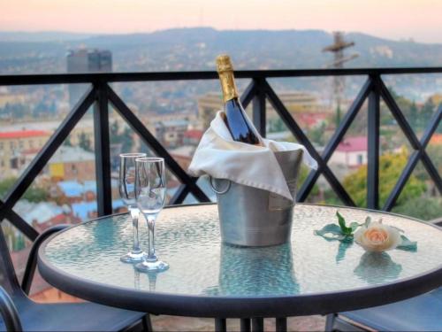 a table with a bottle of wine and two glasses at Sani Apart Hotel in Tbilisi City