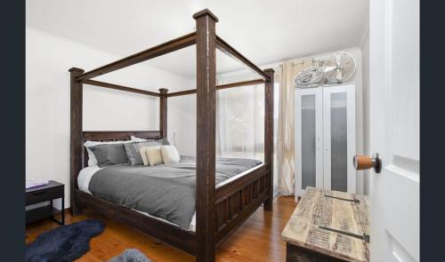 Cozy Stay Cottage في ديلسفورد: غرفة نوم مع سرير مظلة في غرفة