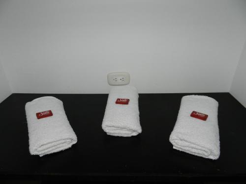 three towels are sitting on a black table at Hotel Sucre Del Bosque in Palmira