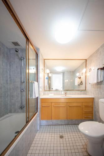 a bathroom with a tub and a toilet and a sink at Bougainvillea Gold Coast Holiday Apartments in Gold Coast