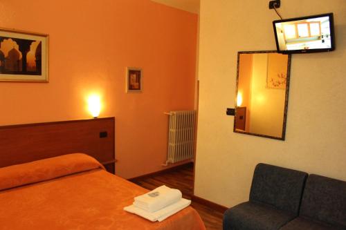 a hotel room with a bed and a chair and a mirror at Hotel America in Milan
