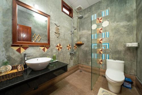 a bathroom with a sink and a toilet and a shower at An Bang Gold Coast Beach Villa in Hoi An