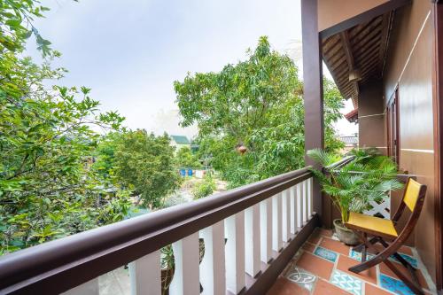 a balcony with a view of trees at An Bang Gold Coast Beach Villa in Hoi An
