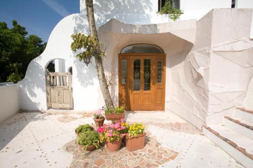 una casa blanca con macetas delante de una puerta en 伊豆下田 - Shimoda Beach House2 - ペット可, en Shimoda