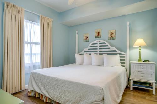 a bedroom with a white bed and a window at Seychelles Beach Resort IV in Panama City Beach