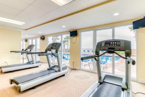 a fitness room with treadmills and ellipticals at Sunrise Beach Resort V in Panama City Beach