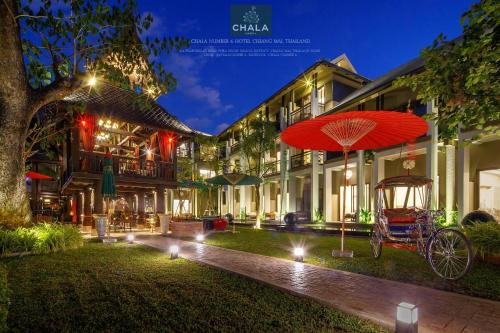 a red umbrella in front of a building at night at Chala Number6 in Chiang Mai