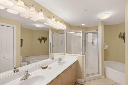 a bathroom with two sinks and a shower and a tub at Dunes of Seagrove Condominiums in Seagrove Beach