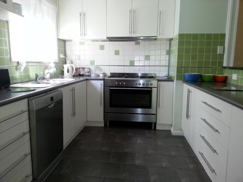 a kitchen with white cabinets and a black oven at HEALESVILLE GETAWAY in Healesville