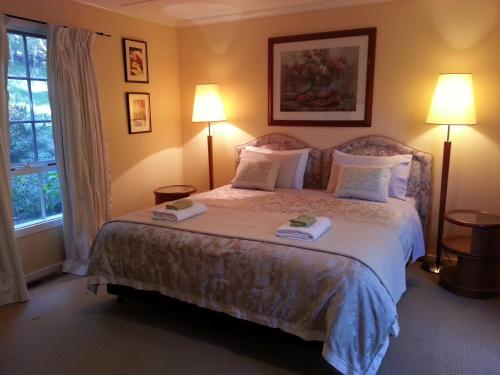 a bedroom with a large bed with two lamps at HEALESVILLE GETAWAY in Healesville