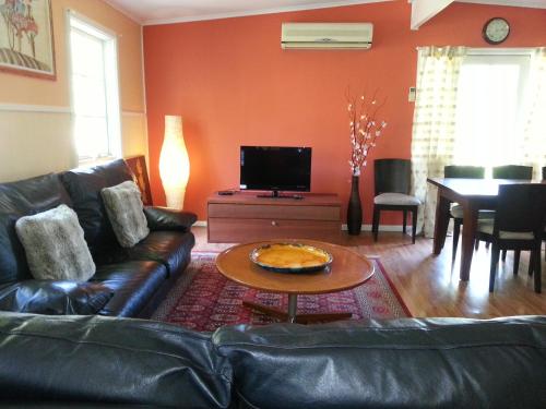 a living room with a leather couch and a table at HEALESVILLE GETAWAY in Healesville