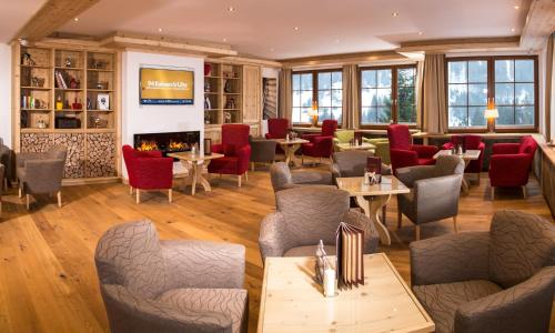 a restaurant with tables and chairs and a fireplace at Hotel Karl Schranz in Sankt Anton am Arlberg