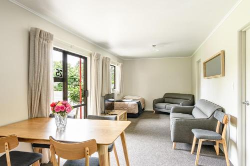 a living room with a table and a couch at Motueka Garden Motel in Motueka