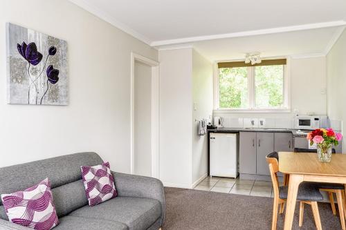 a living room with a couch and a table at Motueka Garden Motel in Motueka