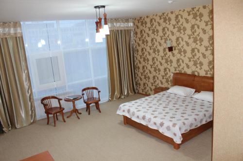 a bedroom with a bed and a table and chairs at Ayhan Hotel in Aktobe