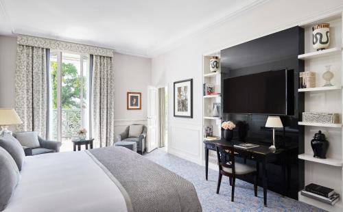 a hotel room with a bed and a desk with a television at InterContinental Paris Le Grand by IHG in Paris