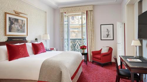 a hotel room with a bed and a red chair at InterContinental Paris Le Grand by IHG in Paris