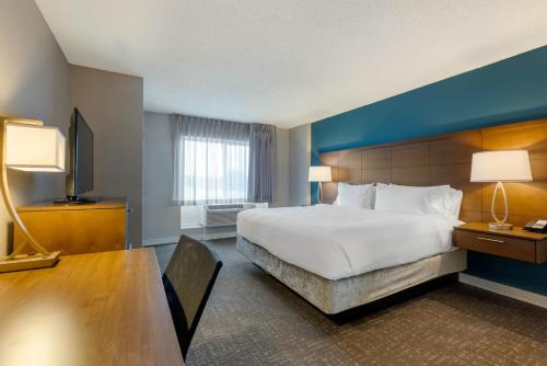Staybridge Suites Orlando Royale Parc Suites, an IHG Hotel في أورلاندو: غرفة الفندق بسرير كبير ومكتب