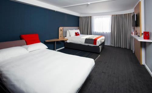 a hotel room with two beds and a television at Holiday Inn Express Portsmouth – North, an IHG Hotel in Portsmouth