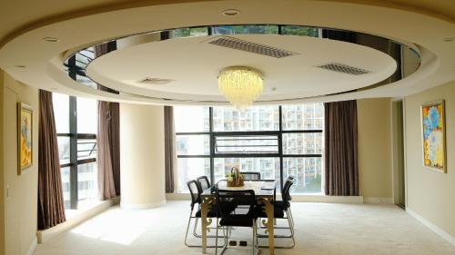 a dining room with a table and a chandelier at Cheng Bao Hotel Shantou Mixc Branch in Shantou