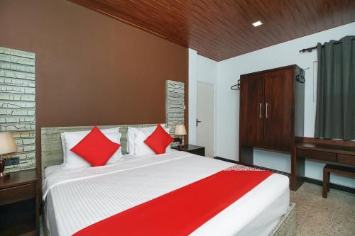 a bedroom with a large bed with red pillows at Hotel 198 Negombo in Negombo