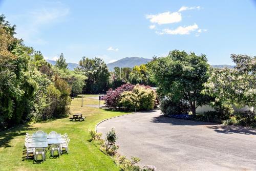 a group of chairs and a picnic table in a park at Motueka Garden Motel in Motueka