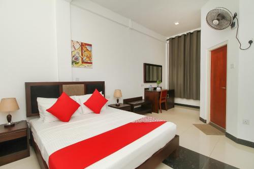 a bedroom with a large bed with red pillows at Hotel 198 Negombo in Negombo