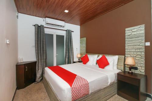 a bedroom with a large bed with red pillows at Hotel 198 Negombo in Negombo