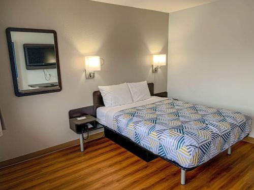 a hotel room with a bed and a mirror at Motel 6-Dayton, OH in Dayton