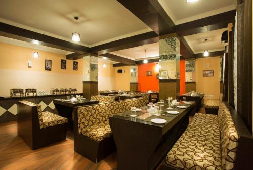 a restaurant with tables and chairs in a room at Golden Star Continental & Spa in Gangtok