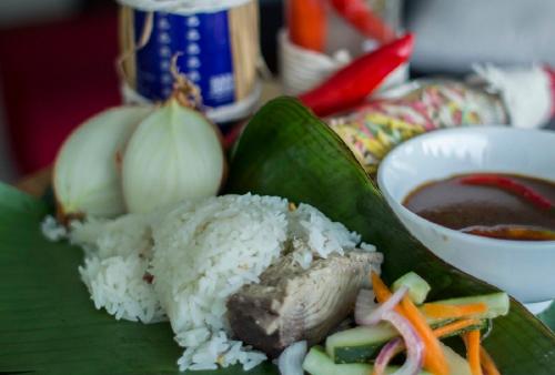 a plate of rice and meat and vegetables on a banana leaf at Raia Hotel & Convention Centre Terengganu in Kuala Terengganu