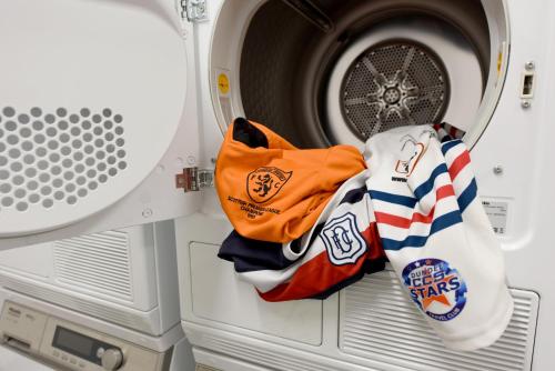 a washing machine with a pile of clothes in it at Staybridge Suites - Dundee by IHG in Dundee