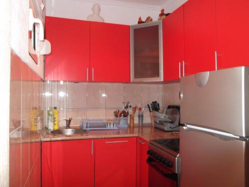 a red kitchen with red cabinets and a refrigerator at Guest House Kavedžić in Žabljak