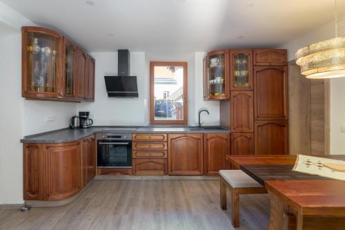 a kitchen with wooden cabinets and a wooden table at Old Mill House in Bohinj