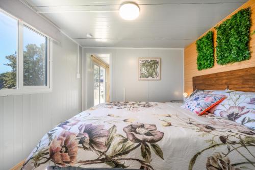 een slaapkamer met een groot bed en een raam bij Cosy cabin to stay even better than Glamping in Pukekohe East