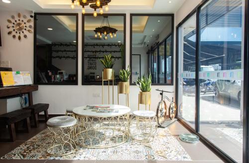 M Design Hotel @ Taman Pertama في كوالالمبور: طاولة و اثنين من الكراسي في غرفة مع نوافذ
