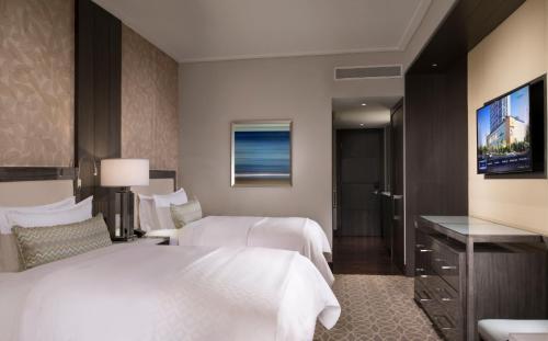 a hotel room with two beds and a television at InterContinental Real Santo Domingo by IHG in Santo Domingo