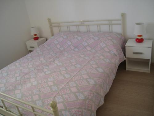 een slaapkamer met een bed met een roze dekbed bij Apartments Villa Kosović in Dubrovnik