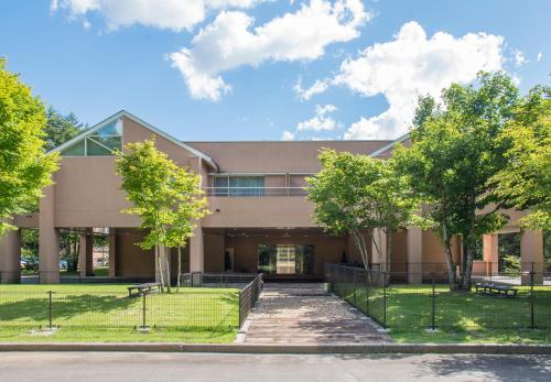 a large building with trees in front of it at Yutorelo Tateshina Hotel with DOGS in Chino