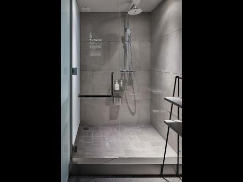 a bathroom with a shower with a shower head at 9h nine hours Nagoya station in Nagoya