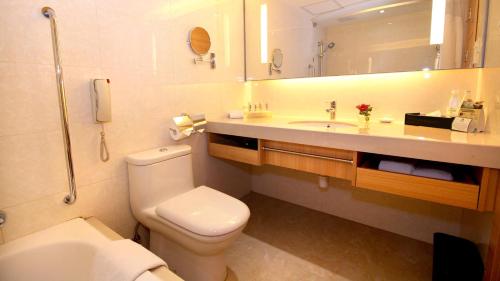 a bathroom with a toilet and a sink and a mirror at Holiday Inn Macau by IHG in Macau