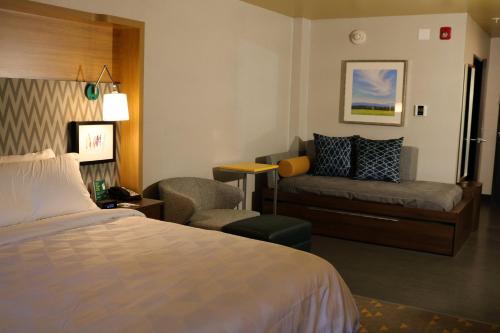 Habitación de hotel con cama y sofá en Holiday Inn - Jonesboro, an IHG Hotel, en Jonesboro