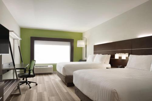 a hotel room with two beds and a desk at Holiday Inn Express Knoxville-Strawberry Plains by IHG in Knoxville