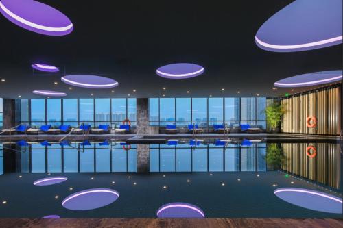 a large lobby with blue chairs and windows at InterContinental Taiyuan, an IHG Hotel in Taiyuan