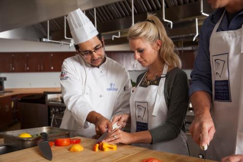 a man and woman in a kitchen preparing food at Holiday Inn Niagara Falls-Scenic Downtown, an IHG Hotel in Niagara Falls