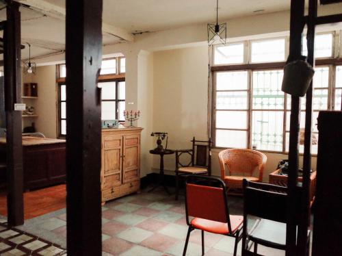 台南市にあるNeat Hostelのベッド、テーブル、椅子が備わる客室です。